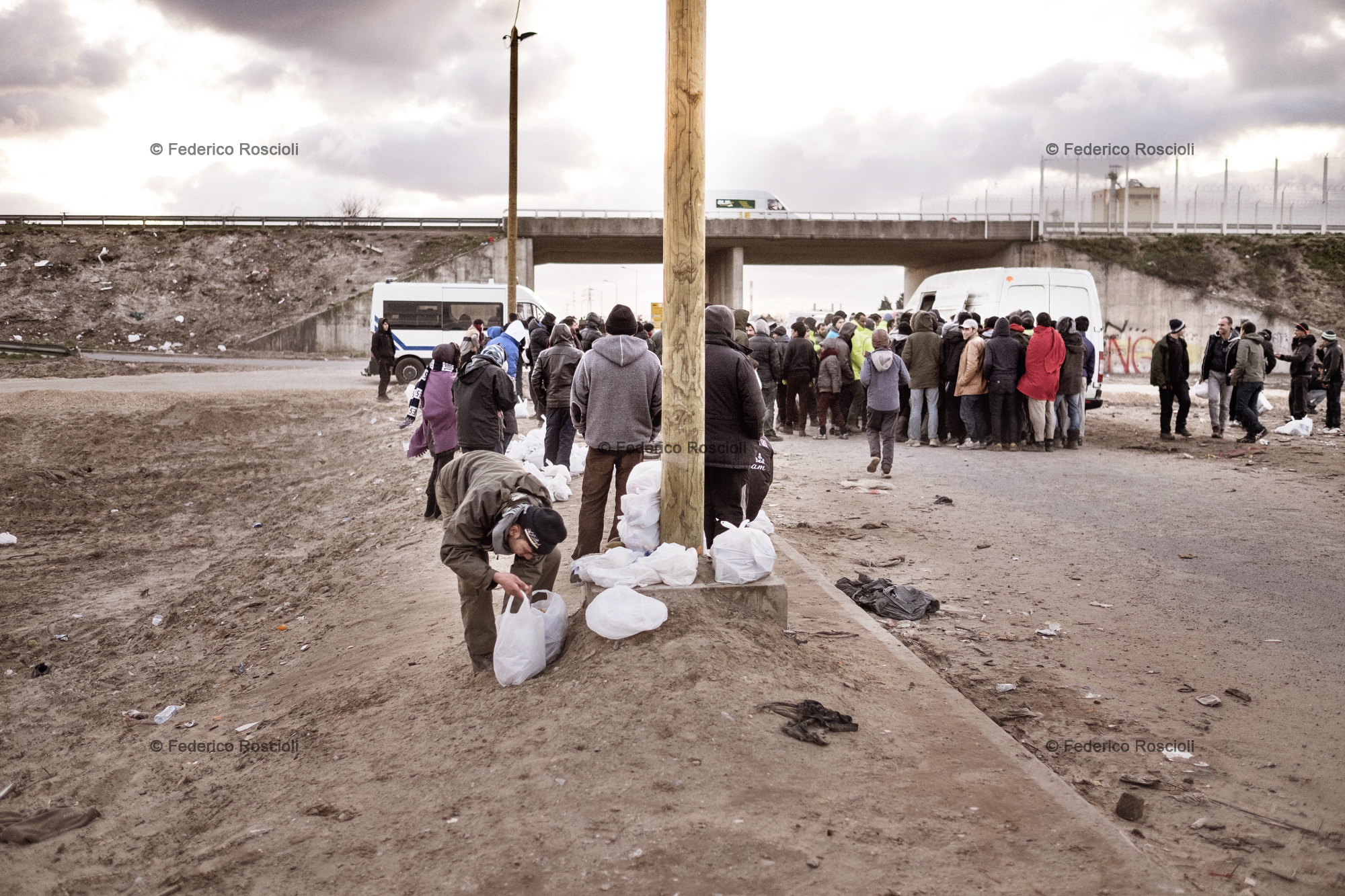 Calais, France. February 28, 2016. Food distribution at the camp entrance. Not all the migrants join in for distribution because they are wealthy and able to buy food.
